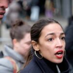 woman speaking outdoors with red lipstick and hoop earrings