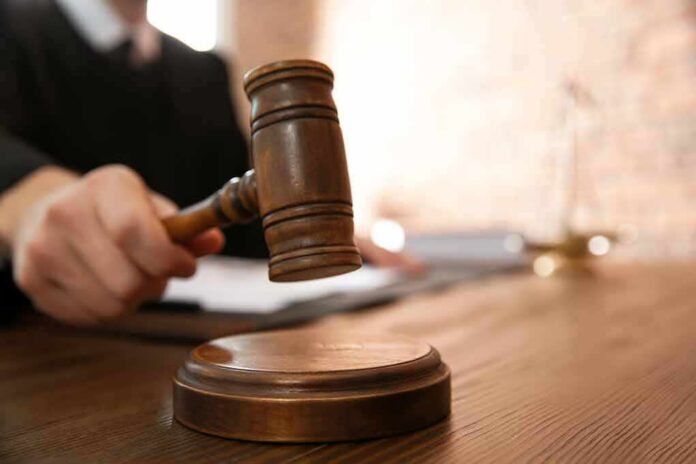 Judge's gavel striking sound block on wooden desk