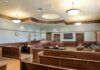 Bombshell Ruling Guts 9/11 Prosecution – 27 Years Later! Empty courtroom with wooden benches and judge's bench