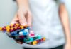 Hand holding blister packs of assorted capsules