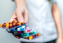 Hand holding blister packs of assorted capsules