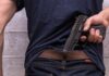 Nightclub Bloodbath Near Cape Town Person tucking a handgun into the back waistband
