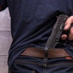 Nightclub Bloodbath Near Cape Town Person tucking a handgun into the back waistband