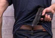 Nightclub Bloodbath Near Cape Town Person tucking a handgun into the back waistband