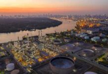 Industrial oil refinery complex beside a river at dusk