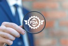Magnifying glass held by person in suit showing FDA badge icon