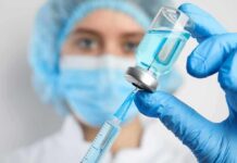 Birthright Baby Boom Under Federal Microscope Healthcare worker drawing blue liquid from vial with syringe
