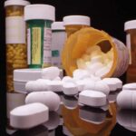 Prescription pill bottles and spilled white tablets