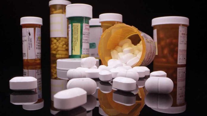Prescription pill bottles and spilled white tablets