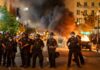 IOPC Probe Launched After A66 Bloodshed Christian Jones and Teddy Williams among police line at night protest with fire and smoke