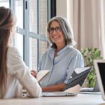 Nevada Court Nukes 40-Year Abortion Rule Smiling woman with gray hair talking in a modern office