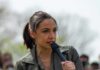 AOC speaking into a handheld microphone outdoors