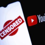 Censorship Clash: Musk Drops Banned Movie smartphone screen with censored stamp next to YouTube logo