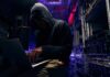 Permitting Whiplash Jolts Oracle’s Data Push Hooded person using a laptop in a dark server room