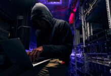 Permitting Whiplash Jolts Oracle’s Data Push Hooded person using a laptop in a dark server room