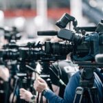 New King, Hard Limit — Constitution First Broadcast cameras on tripods at a press event