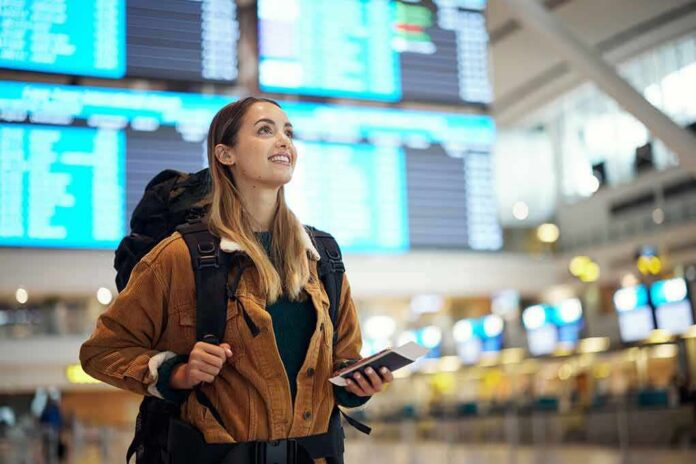 traveler with backpack checking flight information boards