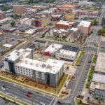 Aerial view of a downtown city block with streets and mixed-use buildings