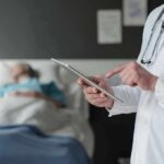 No Warning, Deadly Bleed at Gym Doctor using tablet beside hospital patient