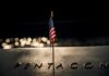 Small American flag on a memorial with bokeh lights at night