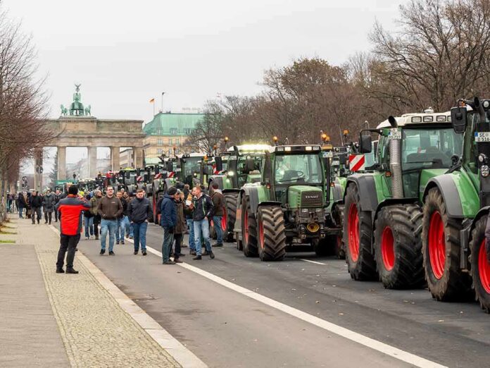 shutterstock_2402212681 Row of tractors lined up on a city street with people walking among them