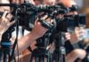 Deadlock Drama: Court Walks a Razor television cameras on tripods at a media event