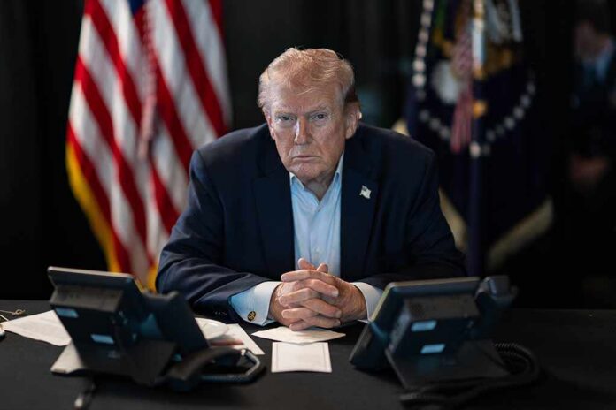 Donald Trump seated at a table between two desk phones