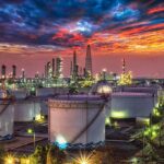 Oil refinery with storage tanks at sunset