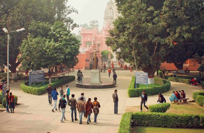 courtyard with statue and people near a pink temple