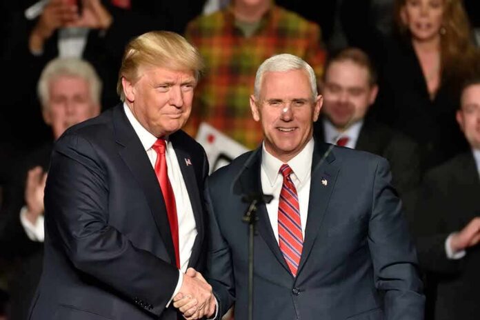 Donald Trump and Mike Pence shake hands on stage; Jeff Lord is in the background