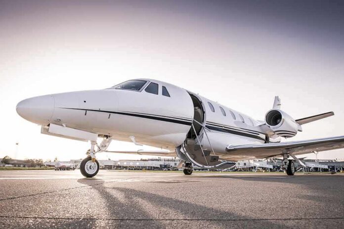 Private jet on airport tarmac with open door at sunset