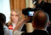 tv camera films interview with blurred speaker