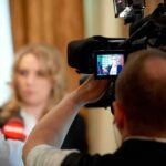 tv camera films interview with blurred speaker