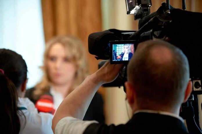 tv camera films interview with blurred speaker