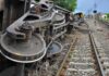 Overturned train cars beside railway tracks