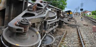 Overturned train cars beside railway tracks