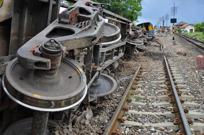 Overturned train cars beside railway tracks