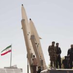 Pause, Not Peace — Next Strike Looms Soldiers stand beside large missiles at an outdoor display