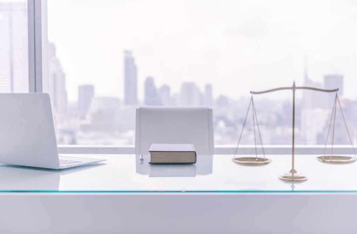 law office desk with laptop book and scales of justice