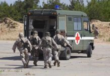 Four Hostages Spark International Military Operation Soldiers running towards a medical vehicle during a military operation