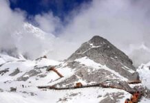 Historic Lair Torched – Mystery Rider Caught Snow-covered mountain with hiking trails and tourists under a cloudy sky