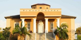 Fraternity house with columns and palm trees in front