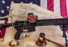 Rifle with NRA badge on Constitution backdrop with scales and gavel