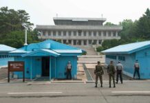 Heated UN Showdown Leads To Diplomat’s Expulsion Military personnel standing near blue buildings at a border crossing