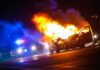 Burning car on a dark street at night