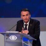 man in suit speaking at a podium