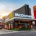 McDonald's restaurant exterior with drive-thru at sunset