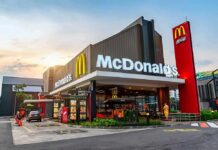McDonald’s AI Pricing Sparks Antitrust Firestorm McDonald's restaurant exterior with drive-thru at sunset