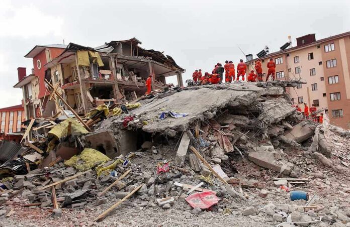 Rescue workers in orange uniforms on a collapsed building site after an earthquake