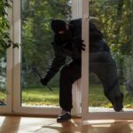 Viral Doorbell Shock – Law Says Otherwise A burglar in dark clothing entering a house through a glass door